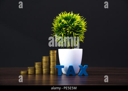 Concetto fiscale. Alfabeto fiscale con la pila di monete in uno sfondo scuro, commerciali e finanziari di concetto idea. Foto Stock
