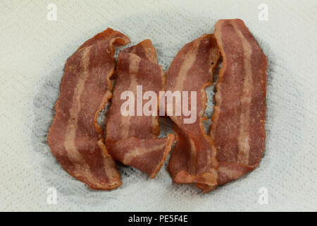 Close up di cotto in forno a microonde la Turchia pancetta cotte su carta assorbente per ridurre e assorbire il grasso in eccesso Foto Stock