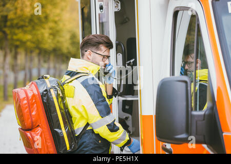 Medico di emergenza utilizzando la radio di ambulanza Foto Stock