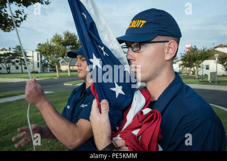 Marinaio reclutare Yiriyah Briggs, nativo di Selmer, Tennessee, marinaio e reclutare Jonathan Jones, nativo di Agoura Hills, in California, alzare la bandiera americana durante la mattina i colori, Sett. 28, 2015 in Coast Guard Training Center Cape May, N.J. La bandiera è alzata ogni mattina e abbassato ogni sera al tramonto del reggimento di reclute attualmente passare attraverso la formazione di base. (U.S. Coast Guard foto di Chief Warrant Officer John Edwards) Foto Stock