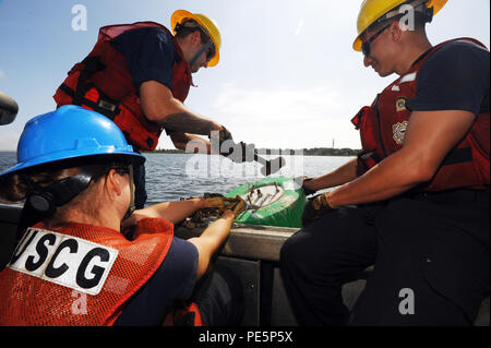 I membri dell'equipaggio dalla Coast Guard ausili alla navigazione Team New York raddrizzare un bullone curvato su una boa lungo il fiume Navesink in New Jersey, Sett. 29, 2015. Gli uomini e le donne di ANT New York sono responsabili per il mantenimento 480 aiuti primario, 96 aiuti stagionali e 9 grandi fari, aiutando a garantire la sicurezza del trasporto marittimo nella regione. (U.S. Coast Guard foto di Sottufficiali di terza classe Flockerzi Ali). Foto Stock