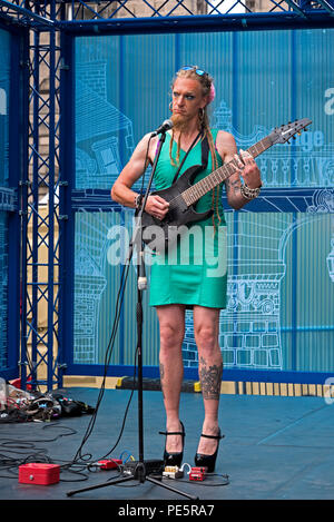 Miss Candy Apple Fondo in tacchi alti e un abito corto esegue su una tappa sulla strada alta durante la Edinburgh Fringe Festival. Foto Stock
