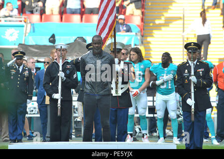 Negli Stati Uniti i membri del servizio con la RAF Molesworth Guardia d'onore, insieme con il cantante Brian McKnight, attendere il completamento della British inno nazionale prima dell'inizio della serie internazionale, Delfini di Miami contro New York getti NFL Game al Wembly Stadium, a Londra il 4 ottobre 2015. Ogni anno, il personale militare dal Regno Unito e gli Stati Uniti si uniscono per le prestazioni degli inni nazionali di entrambi i paesi durante i giochi di NFL a Londra. (U.S. Air Force photo by Staff Sgt. Ashley Hawkins/rilasciato) Foto Stock