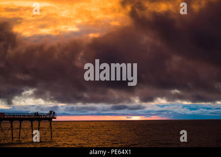 Aberystwyth Wales UK, domenica 12 agosto 2018 UK Meteo: un buio meditabondo e tempestoso cielo sopra Aberystwyth pier al tramonto, alla fine di una giornata di Pesanti rovesci e magie di sole foto © Keith Morris / Alamy Live news Foto Stock