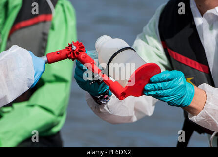 Amburgo, Germania. 13 Ago, 2018. Gli attivisti di Greenpeace prendere i campioni di acqua da sud Elba da un gommone. Su un banco di misurazione attraverso 22 città in Germania, Greenpeace vuole mettere alla prova i laghi, torrenti, fiumi e pozzi privati per i residui da allevamento industriale. Credito: Daniel Bockwoldt/dpa/Alamy Live News Foto Stock