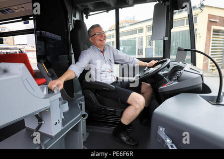 Amburgo, Germania. 13 Ago, 2018. Bus driver Andreas Hinze si siede con il suo nuovo shorts al volante di un autobus pubblico della Hochbahn. Il caldo estivo ha un impatto sul codice di abbigliamento per Amburgo il bus e treno driver, che sono attualmente indossa intorno al 1000 breve pantaloni neri. Credito: Christian Charisius/dpa/Alamy Live News Foto Stock