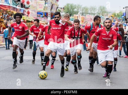 Amburgo, Germania. 13 Ago, 2018. I giocatori di calcio del FC Hamburger Berg dribbling oltre il folk festival "Hamburger Dom'. Dopo due mesi, il club si è conclusa la più lunga di dribbling calcio nel mondo. I giocatori hanno coperto più di 4 mila chilometri con la palla sul loro i piedi, chiaramente superando il vecchio record mondiale di 3,069 chilometri. Credito: Daniel Bockwoldt/dpa/Alamy Live News Foto Stock