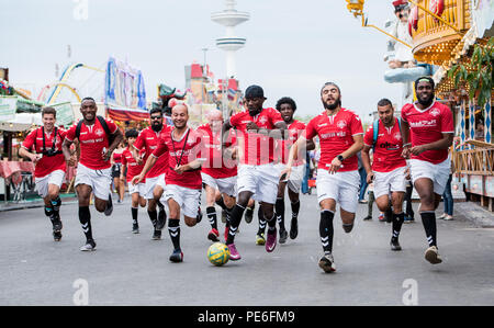 Amburgo, Germania. 13 Ago, 2018. I giocatori di calcio del FC Hamburger Berg dribbling oltre il folk festival "Hamburger Dom'. Dopo due mesi, il club si è conclusa la più lunga di dribbling calcio nel mondo. I giocatori hanno coperto più di 4 mila chilometri con la palla sul loro i piedi, chiaramente superando il vecchio record mondiale di 3,069 chilometri. Credito: Daniel Bockwoldt/dpa/Alamy Live News Foto Stock