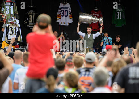 Rosenheim, Baviera. 13 Ago, 2018. Philipp Grubauer, Stanley Cup vincitore con capitali di Washington, solleva l'hockey su ghiaccio trofeo al suo ricevimento nel Parco Mangfall. Nato a Rosenheim, egli è stato il primo portiere tedesco a vincere il North American League titolo. Credito: Matthias esitano di fronte/dpa/Alamy Live News Foto Stock