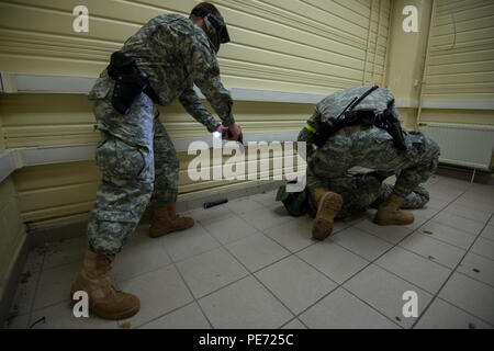 Stati Uniti Army Spc. William Crankshaw, in piedi, e SPC. Richard Fletcher, entrambi i poliziotti militari con la direzione dei servizi di emergenza, U.S. Army Garrison Benelux, l'arresto di un sospetto durante un tiratore attivo per la formazione di una legge sulla certificazione Wingene Air Base, Wingene, Belgio, Ottobre 8, 2015. (U.S. Esercito foto di Visual Information Specialist Pierre-Etienne Courtejoie/rilasciato) Foto Stock