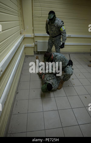 Stati Uniti Army Spc. William Crankshaw cerca un sospetto come Spc. Richard Fletcher sovrintende il funzionamento, entrambi sono poliziotti militari con la direzione dei servizi di emergenza, U.S. Army Garrison Benelux, durante un tiratore attivo per la formazione di una legge sulla certificazione Wingene Air Base, Wingene, Belgio, Ottobre 8, 2015. (U.S. Esercito foto di Visual Information Specialist Pierre-Etienne Courtejoie/rilasciato) Foto Stock