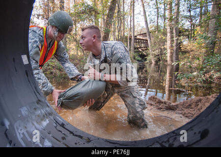 Carolina del Sud esercito Guardia Nazionale 1Lt. Benjamin Sternemann e SPC. Connor Ulyatt con il 1221st Engineering Company da Graniteville, S.C., assicura una sezione del canale sotterraneo di canalizzazione con sacchetti di sabbia come un team di ingegneri lavorano per sostituire un lavato fuori canale sotterraneo su Lexington County road a Gilbert, S.C., 24 ottobre, 2015. Soldati con la S.C. Esercito Guardia Nazionale di continuare a fornire un sostegno diretto alle inondazioni e di ripristino di emergenza di riparazioni su strada come risultato delle recenti inondazioni. La Carolina del Sud la guardia nazionale collabora con federali, statali e locali di gestione delle emergenze le agenzie e i soccorritori. Foto Stock