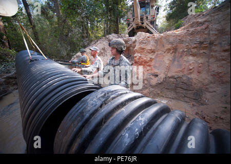 Carolina del Sud esercito nazionale Guard Spc. Connor Ulyatt con il 1221st Engineering Company da Graniteville, S.C. e Sgt. Chase Gambill con 124a società di ingegneria da Saluda, allineare una sezione del canale sotterraneo di tubo come un team di ingegneri lavorano per sostituire un lavato fuori canale sotterraneo su Lexington County road a Gilbert, S.C., 24 ottobre, 2015. Soldati con la S.C. Esercito Guardia Nazionale di continuare a fornire un sostegno diretto alle inondazioni e di ripristino di emergenza di riparazioni su strada come risultato delle recenti inondazioni. La Carolina del Sud la guardia nazionale collabora con federale, statale e locale di emergenza agenzie di gestione Foto Stock