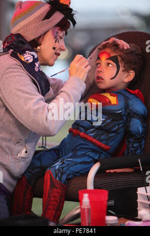 Robin Ware dipinge il volto di 4-year-old Cameron durante il tronco-o-trattare il caso al Marine Corps Air Station Cherry Point, N.C., 26 ottobre, 2015. L'evento è stato ospitato dalla Marine ala squadrone della sede centrale 2 e Marine Aircraft Group 14 family readiness ufficiali per incoraggiare le famiglie ad unirsi in una cassetta di sicurezza e ambiente divertente per Trick or Treat. Durante la manifestazione i membri del servizio, i coniugi e i membri della famiglia sono stati in grado di giocare, guardare film di Halloween e Trick or Treat. (U.S. Marine Corps foto di Cpl. U. B. Roberts/RILASCIATO). Foto Stock