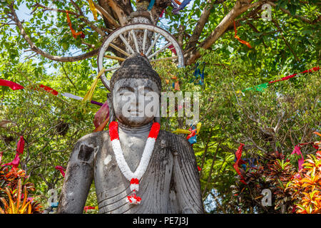 Statua di Pietra del Budda seduto sotto l'albero, con una ghirlanda di bianco e rosso i colori della bandiera indonesiana per Indonesia Giorno Di Indipendenza, Bali, Indones Foto Stock