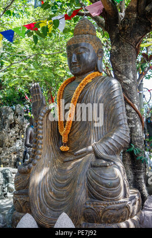 Statua di Pietra del Budda seduto sotto l'albero, Bali, Indonesia. L'immagine verticale. Foto Stock