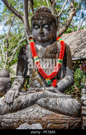 Statua di Pietra del Budda seduto sotto l'albero, Bali, Indonesia. L'immagine verticale. Foto Stock