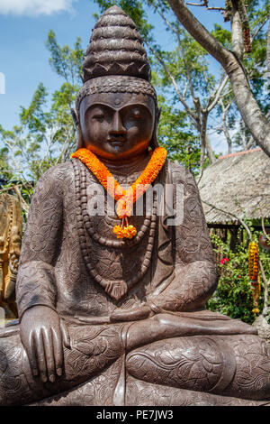 Statua di Pietra del Budda seduto sotto l'albero, Bali, Indonesia. L'immagine verticale. Foto Stock