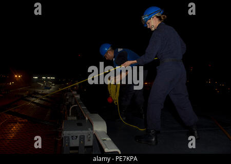 151018-N-AX638-032 OCEANO ATLANTICO (ott. 18, 2015) di Boatswain Mate 3° di classe Luis Romo, da Santa Monica, California, e di Boatswain Mate 3° di classe Kelsey McClean, da Evansville, Ind. gestire una linea di messenger sul ponte di volo dell'assalto anfibio nave USS Kearsarge (LHD 3) come essa tira nella stazione navale di Rota, Spagna, 18 ottobre 2015. Kearsarge, distribuito come parte dell'anfibio Kearsarge Gruppo pronto, sta conducendo operazioni navali negli Stati Uniti Sesta flotta area di operazioni a sostegno degli Stati Uniti per gli interessi di sicurezza nazionali in Europa. (U.S. Foto di Marina di Massa Specialista comunicazione marinaio Tyle Foto Stock