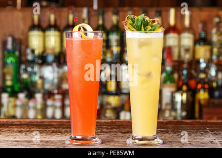 Impostare due cocktail sul bar, cocktail rinfrescanti con ghiaccio su una bottiglia sfocate sullo sfondo Foto Stock