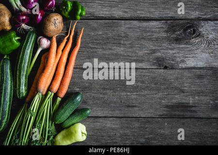 Verdure raccolto sulla vecchia sullo sfondo di legno. Raccolto autunnale. Fresche verdure organiche, vegan lifestyle. Le zucchine, la cipolla, le carote, pepe, cucum Foto Stock