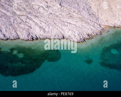 Vista aerea della gente che si muove tra le rocce nel mare. Panoramica del fondale marino visto dal di sopra, di acqua trasparente Foto Stock