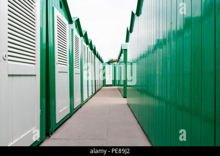 Visualizza in basso di una riga di verde di legno verniciato cabine da spiaggia con porte bianco Foto Stock