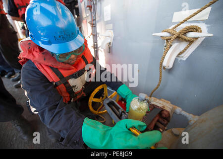 151030-N-JO245-364 mare mediterraneo (ott. 30, 2015) Engineman 3° di classe Levar Cooper, da Brooklyn, N.Y., si prende un campione di carburante diesel marina da una stazione di rifornimento di carburante a bordo del dock anfibio sbarco nave USS Oak Hill (LSD 51) durante un rifornimento in mare con la forza militare di comando Sealift flotta oliatore di rifornimento USNS Leroy Grumman (T-AO 195) ott. 30, 2015. Oak Hill, distribuito come parte dell'anfibio Kearsarge Gruppo pronto, sta conducendo operazioni navali negli Stati Uniti Sesta flotta area di operazioni a sostegno degli Stati Uniti per gli interessi di sicurezza nazionali in Europa. (U.S. Foto di Marina di Massa Communicatio Foto Stock