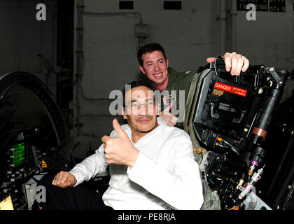 151105-N-PG340-068 sul Mare del Sud della Cina (nov. 5, 2015) - Datuk Seri Hishammuddin Hussein Tun (sinistra), malese il ministro della difesa e di United Malays National Organization (UMNO) Vice Presidente, si siede in un abitacolo di una F/A-18F Super Hornet con Lt. Scott Robertson (a destra), assegnato alla Checkmates di Strike Fighter Squadron (VFA) 211, nell'hangar bay a bordo della portaerei USS Theodore Roosevelt CVN (71). Theodore Roosevelt è operante negli Stati Uniti 7 flotta area di operazioni come parte di una distribuzione a livello mondiale in rotta per il suo nuovo homeport a San Diego per completare una tre-carrier homeport sh Foto Stock