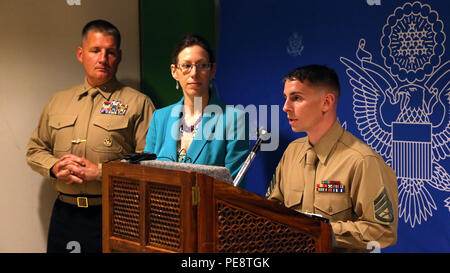 Il personale Sgt. Jason E. Stevens, Marino guardia di sicurezza il distacco commander, U.S. Ambasciata Kathmandu, Nepal parla al personale d'ambasciata, nov. 6, 2015, a una cerimonia per onorare i sei Marines che hanno perso la vita in un incidente in elicottero durante il funzionamento Sahayogi Haat, un aiuto umanitario aiuto in caso di catastrofe la missione in Nepal per più di terremoti in aprile e maggio. Anche sul lato per la dedizione è stata U.S. Ambasciatore a Nepal Alaina B. Teplitz (centro) e Briga. Gen. Tracy W. RE, comandante generale, 3° Marine Logistics Group (sinistra). Foto Stock