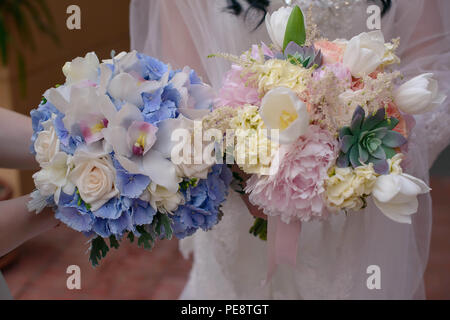 Caucasian le mani delle donne tenendo due eleganti o nuziale bridesmaids mazzi Foto Stock