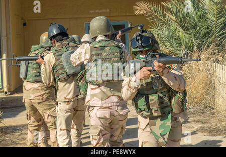 Un soldato iracheno assegnato alla settantunesima esercito iracheno brigata fornisce la protezione posteriore per la sua squadra mentre partecipano in un assalto scenario durante le operazioni in ambiente urbano della formazione di Camp Taji, Iraq, nov. 3, 2015. I soldati hanno partecipato alla formazione per imparare a elimina correttamente le aree popolate durante gli assalti contro lo Stato islamico dell Iraq e il levante. La formazione è parte della costruzione di capacità del partner missione guidata dalla coalizione di membri assegnati al gruppo di attività Taji. (U.S. Esercito foto di Spc. William Marlow/rilasciato) Foto Stock