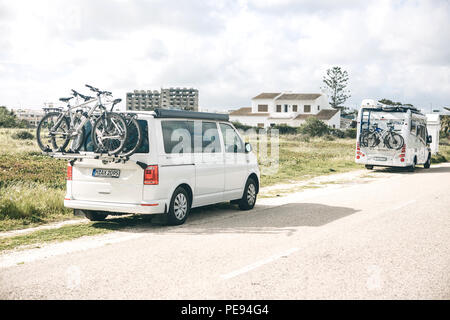 Il Portogallo, Lagos, 12 Aprile 2018: automobili per viaggiare con le biciclette parcheggiate a lato della strada. Il riposo attivo e viaggi in famiglia. Foto Stock