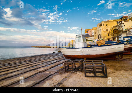 Barca ancorata in un porto di piccole dimensioni in un villaggio di pescatori sulla costa della Sicilia. Foto Stock