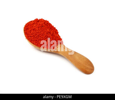 Close-up di legno un cucchiaio pieno di peperoncino rosso o la paprica in polvere isolata su uno sfondo bianco, ad alto angolo di visione Foto Stock