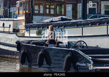 Donna al lavoro su la sua barca a Amsterdam, Paesi Bassi Foto Stock