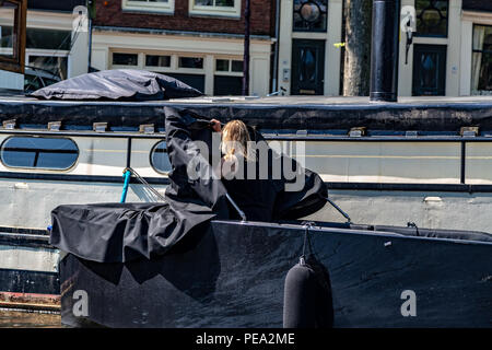 Donna al lavoro su la sua barca a Amsterdam, Paesi Bassi Foto Stock