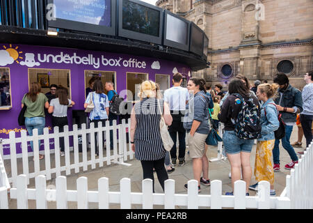 I visitatori di Edinburgh Festival Fringe in fila per i biglietti presso il underbelly box office in Bristo Square nel centro della citta'. McEwan Hall nel retro Foto Stock