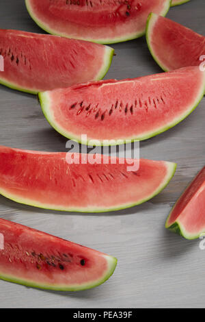 Composizione alimentare fresco con fette di anguria grigio sulla superficie di legno Foto Stock