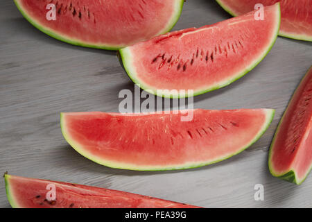 Composizione alimentare fresco con fette di anguria grigio sulla superficie di legno Foto Stock