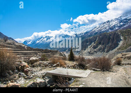 Vista del villaggio di Manang in Himalaya, Nepal. Belle cime innevate e le nuvole. Foto Stock
