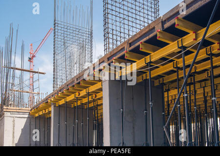 Strutture in cemento armato di un edificio in costruzione. ponteggi e supporto. gru da cantiere Foto Stock