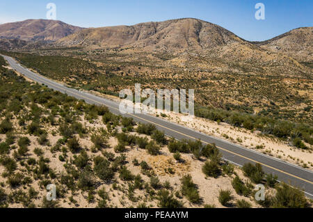 Vista di una strada nel deserto nel cuore del Mojave nel sud della California. Foto Stock