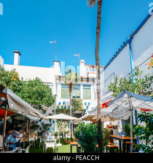 Cordoba, Spagna - 13 Luglio 2018: blu dei vasi da fiori e fiori in un cortile ristorante nel centro storico di Cordoba Foto Stock