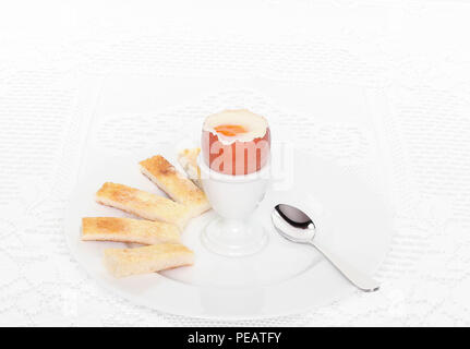 Uova sode con toast imburrato su sfondo bianco. Foto Stock