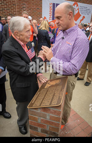 Università di Clemson presidente James Clements condivide un momento con Bataan morte marzo superstite e amata Clemson bocconiano U.S. Esercito Col. (Pensionati) Ben Skardon, dopo una cerimonia dedicando la placca Skardon sta toccando qui, nov. 21, 2015. La placca si trova alla base del Memorial Stadium bandiera pole e onori Skardon per il suo servizio e sacrificio. (U.S. Foto dell'esercito da Staff Sgt. Ken Scar) Foto Stock