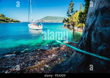 Barche a vela ormeggiata solo in smeraldo laguna nascosta tra i pittoreschi natura mediterranea Isole Ionie, Grecia Foto Stock