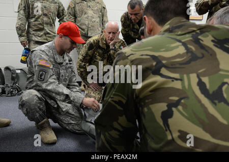 Stati Uniti Il personale dell'esercito Sgt. Lee Stephenson del Airborne Operazioni Speciali Test direzione incarica il partner nazione maestri di salto su come utilizzare gli Stati Uniti Esercito Bail-Out emergenza Suit a Fort Bragg, N.C., nov. 11, 2015. Il funzionamento del giocattolo Drop è la più grande del mondo di combinata airborne operazione con sette partner-nazione paracadutisti che partecipano e soldati consente la possibilità di aiutare i bambini bisognosi di tutto il mondo ricevono giocattoli per le vacanze. (U.S. Esercito foto di PFC. Darion Gibson/rilasciato) Foto Stock