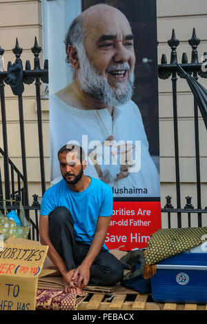 Agosto 13, 2018 - Londra, Regno Unito. Il 13 agosto 2018. Scioperante della fame Ali Mushaima chi è stato al di fuori del Bahrain ambasciata in Belgrave Square dal 1 agosto, chiedendo il suo 70-anno vecchio padre in prigione in Bahrain per essere dato ha urgentemente bisogno di cure mediche, le visite alle famiglie e l'accesso ai libri che era stata attaccata domenica mattina da parte del personale all'interno dell'Ambasciata, con una benna di un liquido sconosciuto che è gettato su di lui dall'ambasciatore balcone. Suo padre Hassan Mushaima e di altri difensori dei diritti umani e i leader dell opposizione sono stati rapiti nel marzo 2017, brutalmente torturati e dato vita sentenc Foto Stock