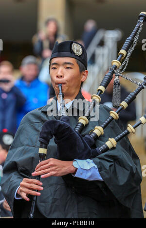 Glasgow, Regno Unito. 14 ago 2018. La pioggia non ha impedito a giocare per i ragazzi di Brisbane College Pipe Band provenienti da Australia che ha intrattenuto il pubblico suonando in scrosci di pioggia a Buchanan Street, Glasgow. Il mondo Pipe Band Championships sono sabato 18 agosto con bande di cornamuse provenienti da tutto il mondo in lizza per il titolo. Jun Oh da Brisbane è uno di loro pipers Credito: Findlay/Alamy Live News Foto Stock